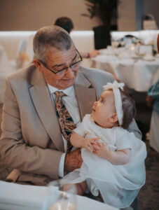 Echange de regard entre un grand-père et sa petite fille sur ses genoux, Belgique