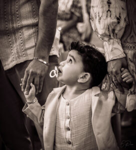 Petit garçon qui tient les mains de ses parents