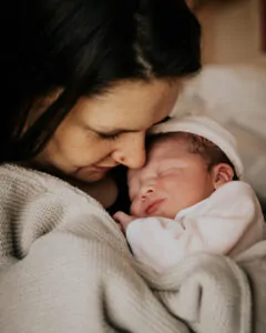 Photo de naissance à l'hôpital, la maman faisant un câlin à sa fille