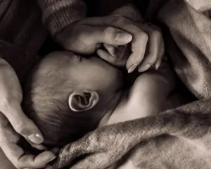 maman recouvrant son bébé de ses mains
