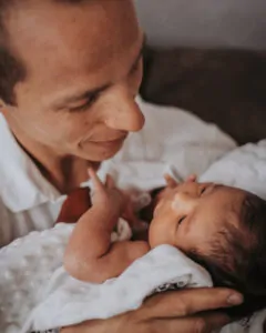 Un papa câlinant son bébé en la regardant tendrement