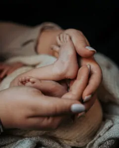 Gros plan sur une maman tenant les pieds de son bébé