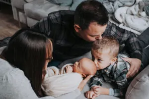 Photo de famille ou le grand frère embrasse sa petite soeur