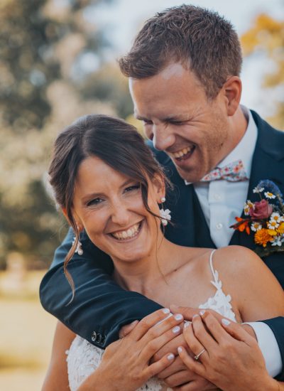 Deux mariés s'enlaçant dans un champ